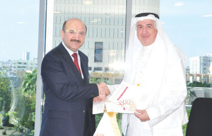 Eng. Hani Salem Sonbol (right), CEO of ITFC, shakes hands with Prof. Mehmet Bulut, President of IZU, at the signing of MoU