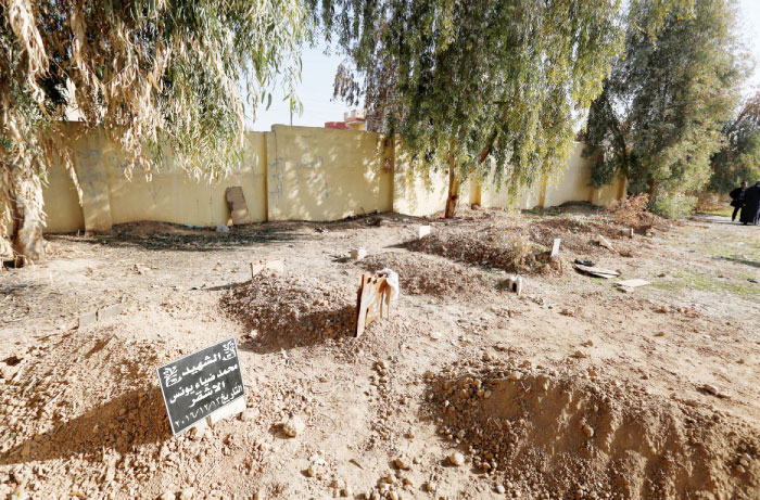 A cemetery for people who were killed in the clashes is seen at a grave in a schoolyard east of Mosul. — Reuters