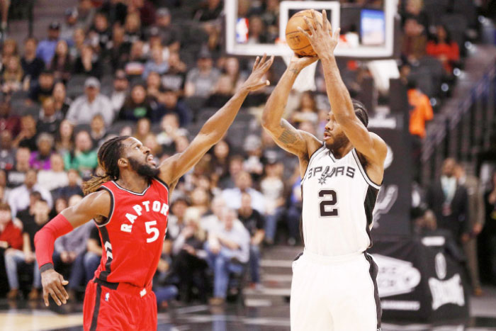 Antonio Spurs’ forward Kawhi Leonard shoots the ball over Toronto Raptors’ forward DeMarre Carroll during their NBA game at AT&T Center in San Antonio Tuesday. — Reuters