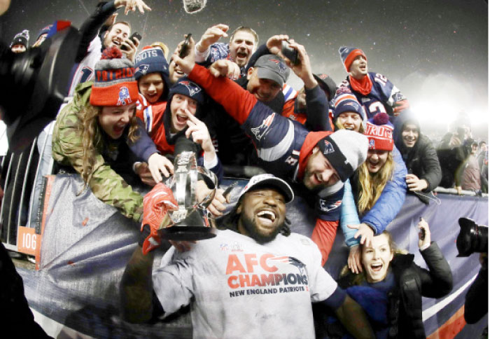 New England Patriots’ running back LeGarrette Blount holds the AFC championship trophy surrounded by fans after the AFC championship NFL football game in Foxborough Sunday. — AP