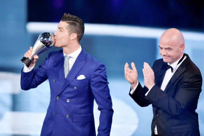 Real Madrid and Portugal’s forward Cristiano Ronaldo (L) kisses his trophy after winning The Best FIFA Men’s Player of 2016 Award next to FIFA President Gianni Infantino in Zurich Monday. - AFP