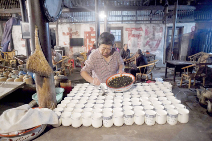 An elderly woman preparing tea for customers at a hundred years old teahouse in the early morning in Chengdu, southwest China’s Sichuan province. — AFP