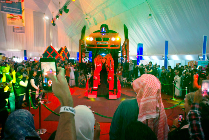 Visitors watch the Turkish made robot “Letrons”, as it morphs from a car to a giant robot.