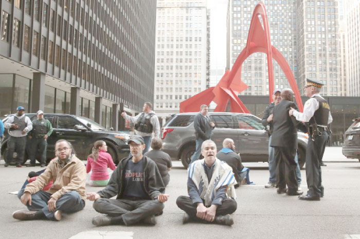 Police arrest demonstrators for blocking a street during a protest against President Donald Trump’s proposed policies on combating crime  in Chicago, Illinois. — AFP
