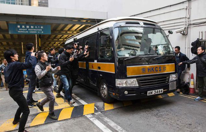 Media surround a prison van holding seven police officers that were convicted of assaulting Civic Party activist Ken Tsang during the 2014 pro-democracy protests, as it leaves the District Court in Hong Kong on Tuesday. — AFPv