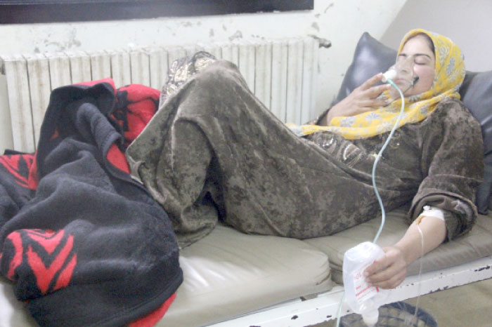A woman, affected by a gas attack, breathes through an oxygen mask inside a field hospital in Kfar Zeita village in the central province of Hama in this file photo. — Reuters