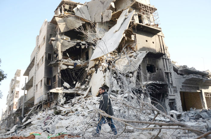 A Syrian man walks past a damaged building in the northwestern border town of Al-Bab after Turkish-backed rebels announced the recapture of the town from the Daesh group. — AFP