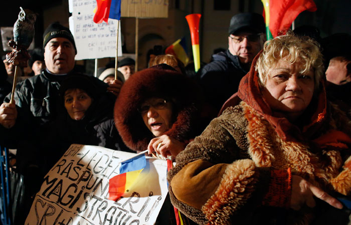 People shout slogans during a protest in Bucharest, Romania, Monday,. The leader of Romania's ruling center-left coalition said Monday the government won't resign following the biggest demonstrations since the end of communism against a measure that would ease up on corruption. — AP