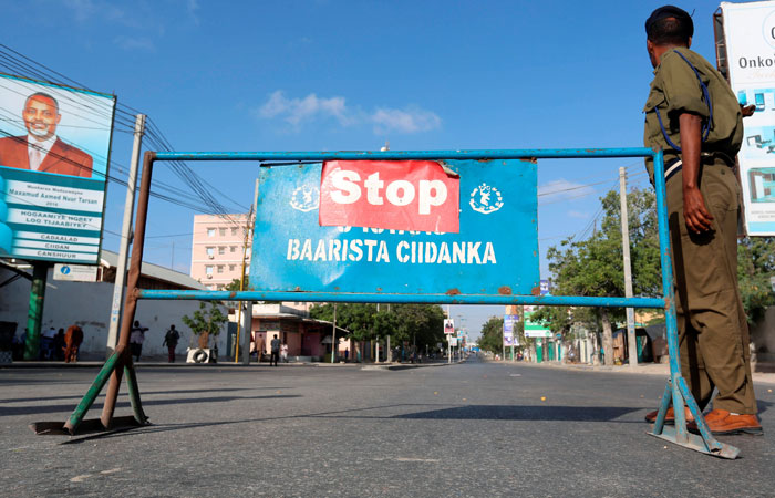 A Somali policeman stands guard along a road, which was blocked to control motor vehicle traffic, during a security lock down in Somalia's capital Mogadishu, Tuesday. — Reuters