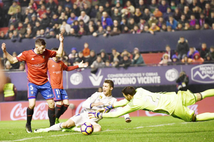 Real Madrid’s Cristiano Ronaldo (C) fights for the ball with Osasuna’s goalkeeper Salvatore Sirigu during their Spanish La Liga soccer match at El Sadar Stadium in Pamplona, northern Spain, Saturday. — AP