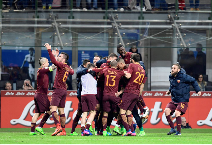 AS Roma›s Argentinian midfielder Diego Perotti is congratulated by teammates after scoring during the Italian Serie A football match at the San Siro stadium in Milan on Sunday. — AFP