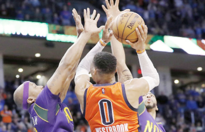 Oklahoma City Thunder guard Russell Westbrook, center, is blocked by New Orleans Pelicans forward Dante Cunningham, left, and New Orleans Pelicans forward Anthony Davis, right, on the way to the basket during the second half of an NBA basketball game in Oklahoma City, Sunday. — AP