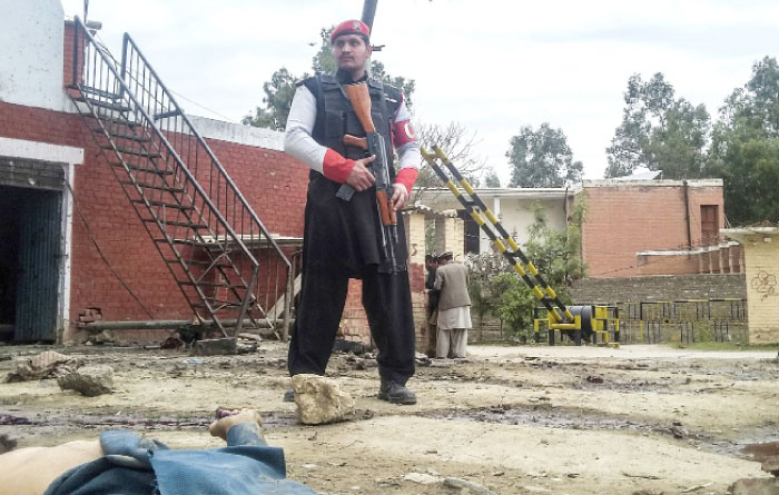 A Pakistani security officer stands alert at the site of a bombing in Ghalanai in the Pakistan’s tribal region of Mohmand on Wednesday. — AP