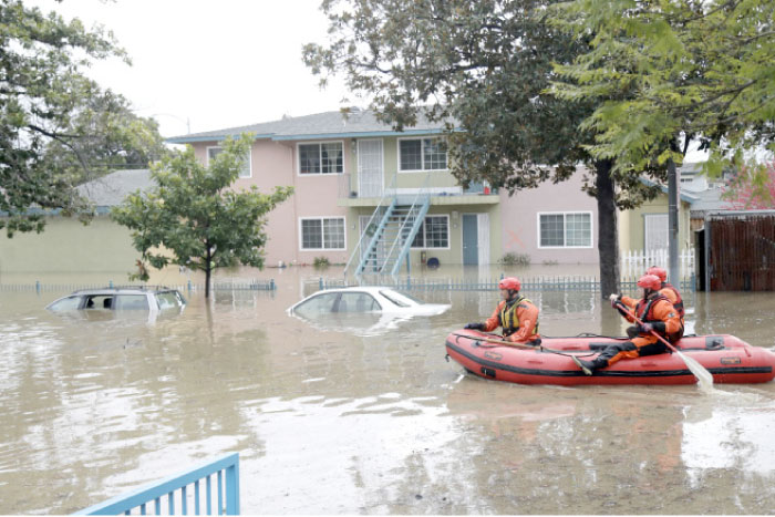 Rescuers travel by boat through a flooded neighborhood looking for stranded residents in San Jose, California, on Tuesday. — AP