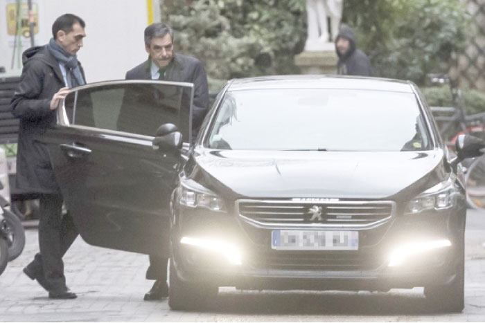 French presidential election candidate for the right-wing Les Republicains (LR) party Francois Fillon (2L) steps in a car as he leaves his home to his campaign headquarters on Monday in Paris. — AFP