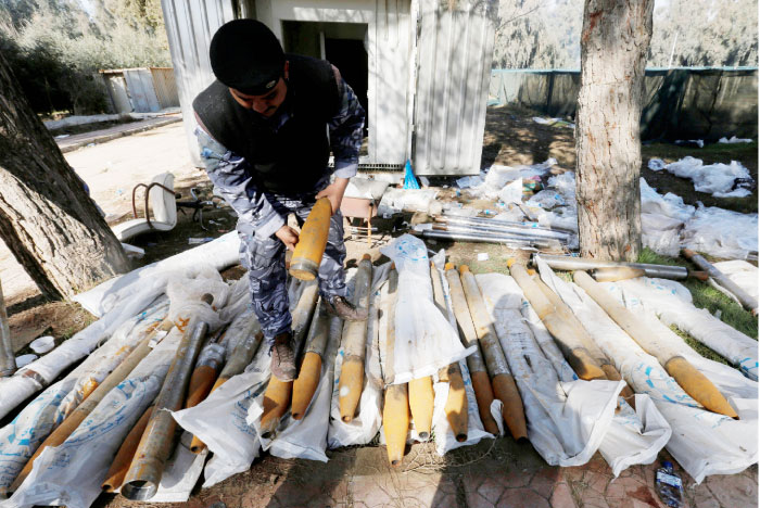 An Iraqi federal police officer inspects weapons that were used by Daesh militants in Mosul. — Reuters