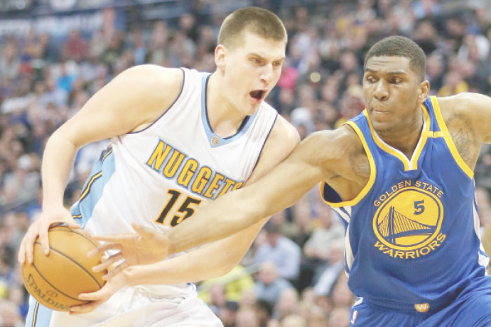 Nikola Jokic No. 15 of the Denver Nuggets drives to the basket against Kevin Looney No. 5 of the Golden State Warriors at the Pepsi Center on Monday in Denver, Colorado. — AFP