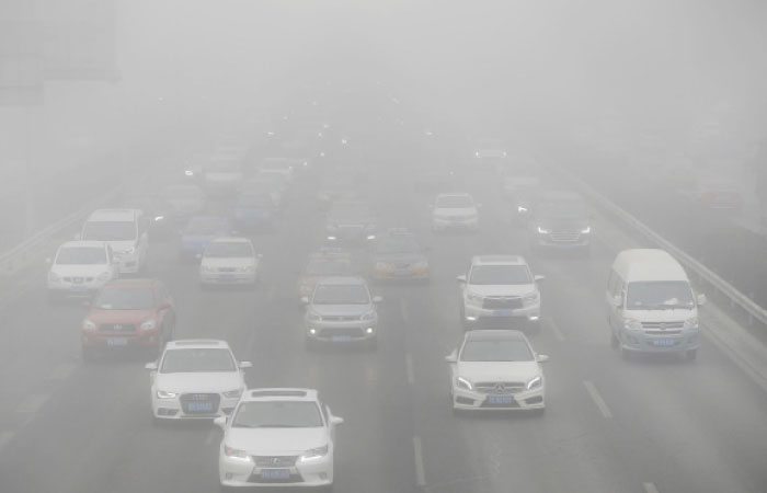 Vehicles drive on the Fourth Ring Road during the smog in Beijing, China. — Reuters