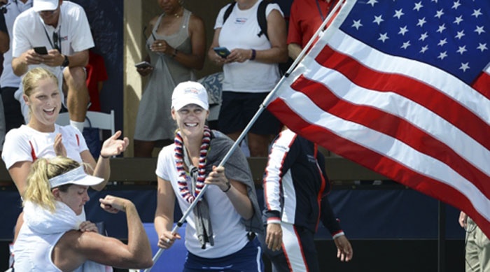 CoCo Vandeweghe flexes her muscles while celebrating with USA Fed Cup teammates Alison Riske, right, and Shelby Rogers after her singles win clinched the team victory over Germany at the Royal Lahaina Tennis Ranch in Lahaina, Hawaii on Sunday. — AP