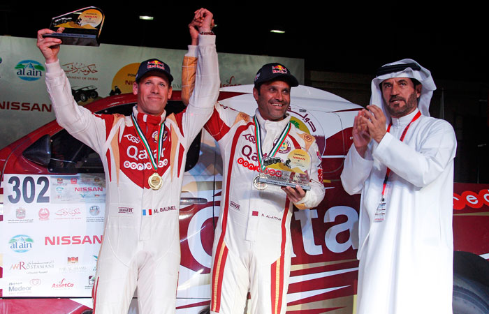 Winners Nasser Al-Attiyah and Mathieu Baumel pose with Mohammed Ben Sulayem.