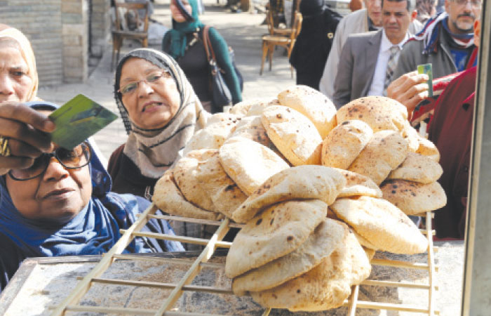 People buy bread at a bakery in Cairo. — Reuters photos