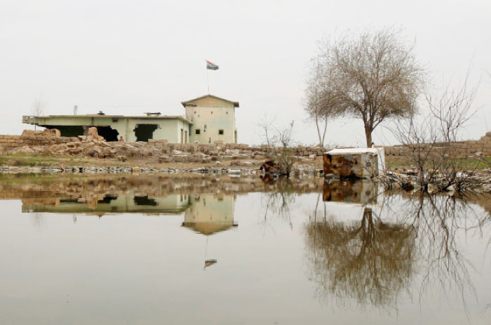 An Iraqi flag waves atop a destroyed building after the area was retaken by Iraqi forces, near Mosul, Wednesday. — Reuters