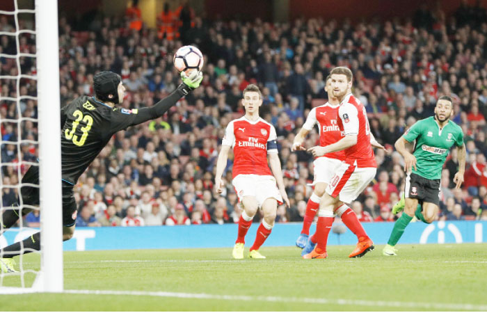 Lincoln’s Nathan Arnold has a shot saved by Arsenal’s Petr Cech during their FA Cup quarterfinal match at the Emirates Stadium Saturday. — Reuters
