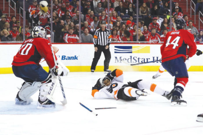 Wayne Simmonds of the Philadelphia Flyers falls on the ice in front of goalie Braden Holtby (L) of the Washington Capitals during their NHL game at Verizon Center in Washington Saturday. — AFP