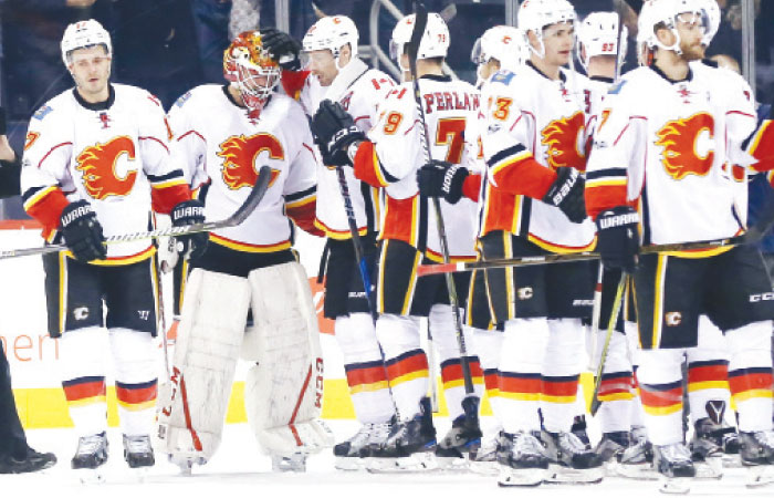 Players of the Calgary Flames celebrate their win over the Winnipeg Jets after their NHL game at MTS Centre in Winnipeg Saturday. — AP