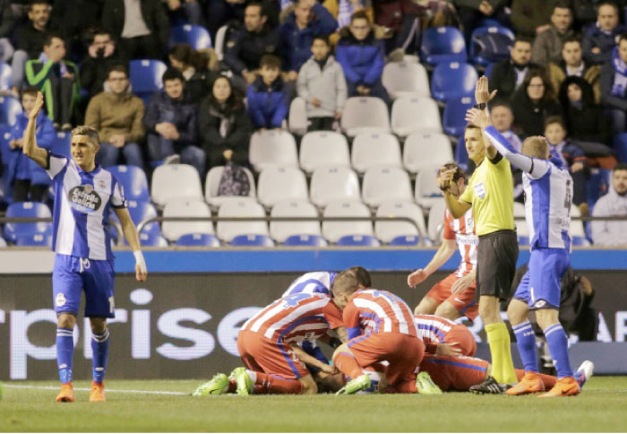 Referee Carlos Clos Gomez calls for medical assistance as Atletico Madrid’s Fernando Torres lies injured on the ground during the Spanish league match Thursday. — Reuters
