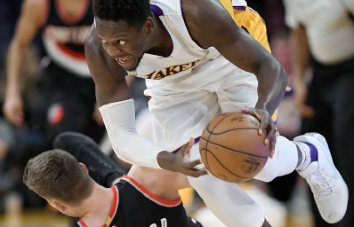Los Angeles Lakers forward Julius Randle, right, heads away after going for a loose ball along with Portland Trail Blazers forward Meyers Leonard during the first half of an NBA basketball game, Sunday in Los Angeles. — AP