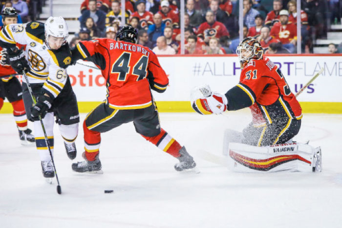 Calgary Flames’ goalie Chad Johnson (R) guards his net as Boston Bruins’ left wing Brad Marchand (L) shoots during their NHL game in Calgary Wednesday. — Reuters