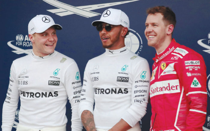 Mercedes driver Lewis Hamilton (C) of Britain reacts after setting pole position in qualifying alongside teammate Valtteri Bottas (L) of Finland and Ferrari’s Sebastian Vettel of Germany at the Australian Grand Prix in Melbourne Saturday. — Reuters