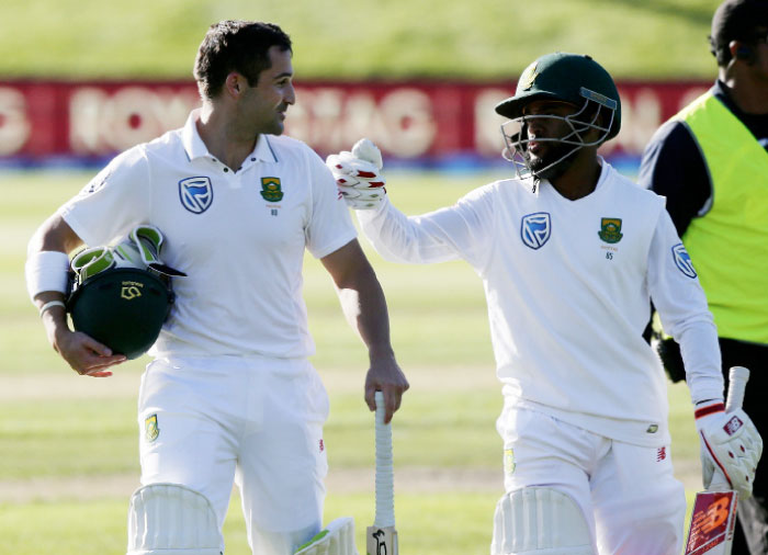 South Africa’s Dean Elgar (L) is congratulated by teammate Temba Bavuma as they leave the field following the first day’s play of the first cricket Test against New Zealand at University Oval, Dunedin, New Zealand, Wednesday. — AP
