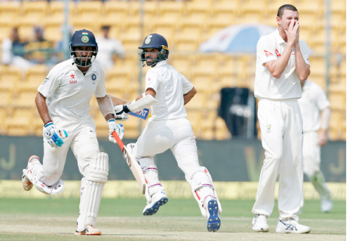 India’s Cheteshwar Pujara and Ajinkya Rahane run between the wickets as Australia’s Josh Hazlewood looks on during the second Test at Bengaluru.  — Reuters