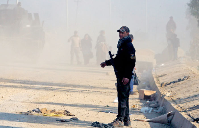 An Iraqi special forces soldier stands guard while displaced Iraqis flee their homes, as Iraqi forces battle with Daesh militants, in western Mosul. — Reuters