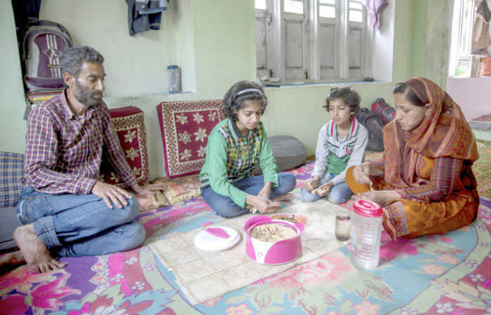 Sonaullah Dar, left, a former Kashmiri militant watches as her daughters Malaika and Emaan along with their mother Imrana Mehar eat lunch at their residence in Delina, 50 km north of Srinagar, India, in this June. 2, 2016 photo. — AP