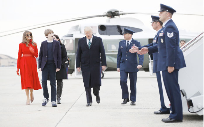 President Donald Trump, with, his wife first lady Melania Trump and their son Barron Trump walk with 89th Airlift Wing Commander Col. Eaton and his wife as they walk from Marine One for a brief switch to Air Force One at Andrews Air Force Base, Md., Friday. — AP