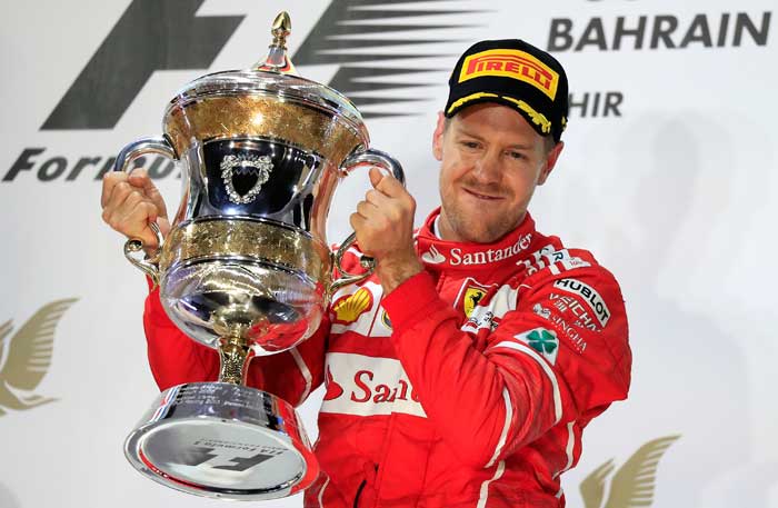 Ferrari driver Sebastian Vettel of Germany celebrates on the podium with his trophy after winning the Bahrain Grand Prix in Sakhir, Bahrain, Sunday. — AP