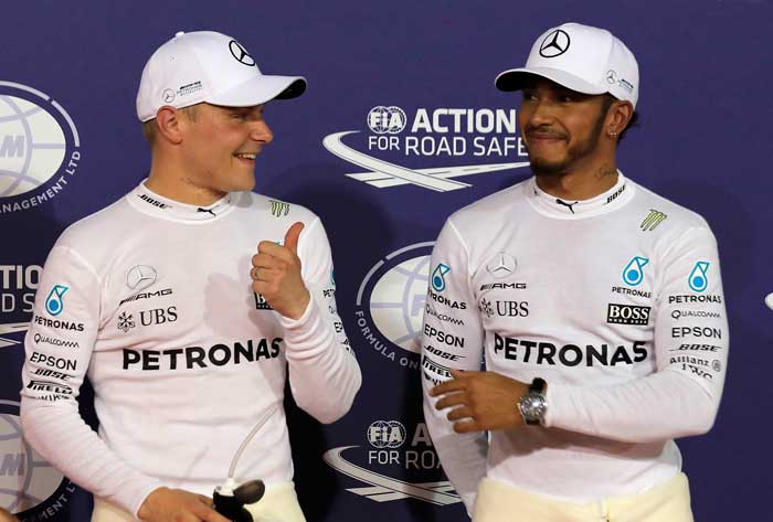 Mercedes drivers Valtteri Bottas (L) of Finland and Lewis Hamilton of Britain pose after the qualifying session for the Bahrain Formula One Grand Prix at Sakhir circuit Saturday. — AP