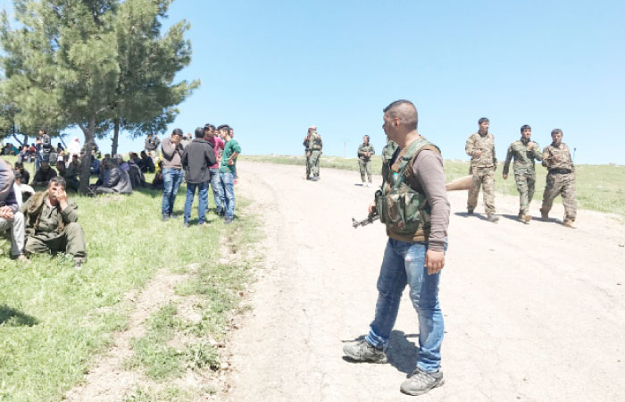 Kurdish fighters from the People’s Protection Units (YPG) gather near their headquarters after it was hit by Turkish airstrikes in Mount Karachok near Malikiya, Syria, on Tuesday. — Reuters