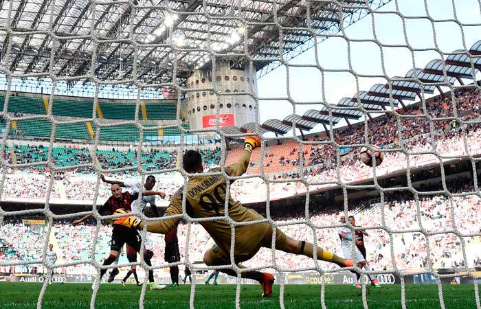 Empoli's Senegalese forward Mame Baba Thiam (top) scores against AC Milan's goalkeeper Gianluigi Donnarumma during the Italian Serie A football match AC Milan vs Empoli at the San Siro stadium in Milan on Sunday. — AFP