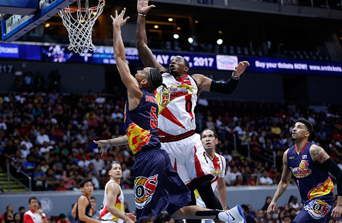 San Miguel Beer's Charles Rhodes rises to block a layup by Rain or Shine's Gabe Norwood in their PBA Commissioner's Cup at the Mall of Asia Arena Saturday night.