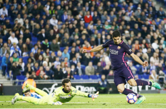 Barcelona’s Luis Suarez (R) scores during the Spanish La Liga match against Espanyol at RCDE Stadium in Cornella Llobregat, Spain, Saturday. — AP