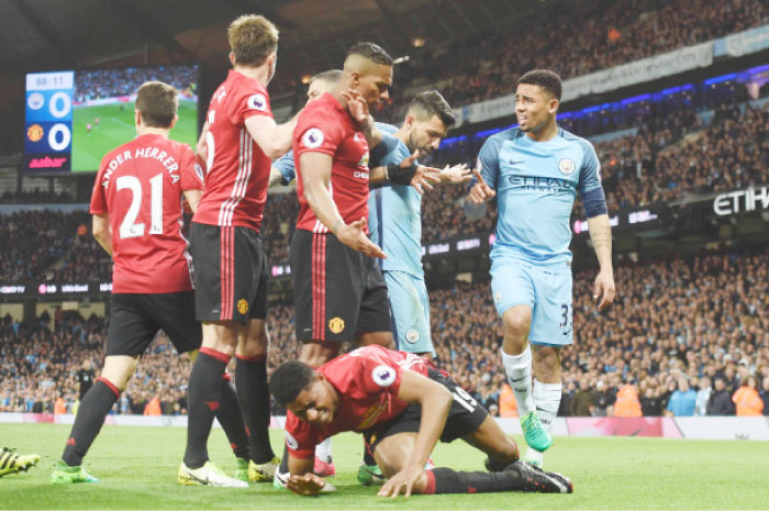 Manchester United’s English striker Marcus Rashford (C floor) lies hurt on the pitch after a late challenge from Manchester City’s Brazilian striker Gabriel Jesus (R) during the English Premier match in Manchester Thursday. — AFP