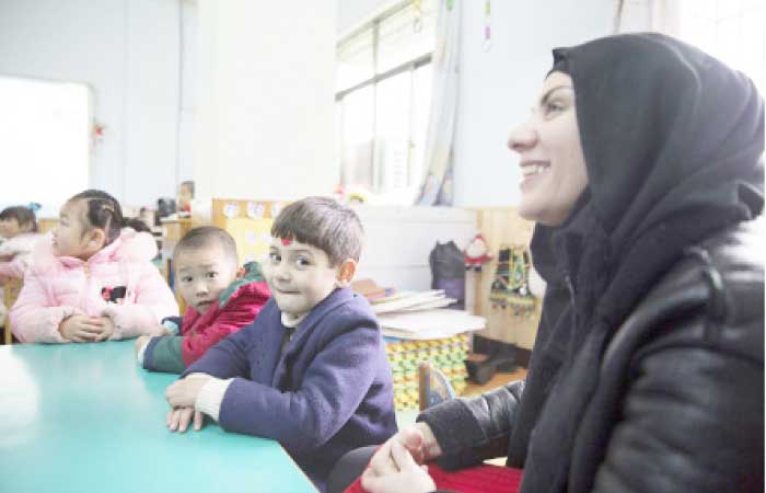 Manar Abdulhussein, an Iraqi migrant, laughs in a kindergarten her son attends in Yiwu, China. — Reuters