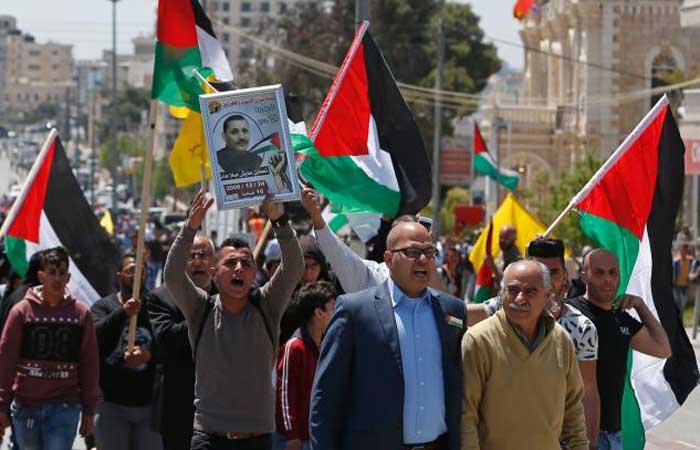 Palestinian protesters wave their national flag during a demonstration in the West Bank town of Bethlehem to show their support for Palestinians imprisoned in Israeli jails after hundreds of detainees launched a hunger strike on April 17, 2017. _ AFP