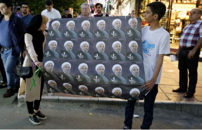 Supporters of Iranian President and election candidate Hassan Rohani distribute brochures ahead of the presidential election in the streets of the capital Tehran. — AFP