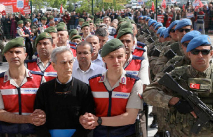 Turkish Gendarmerie escort defendants Akin Ozturk (2L) and others involved in last Julys attempted coup in Turkey as they leave the prison where they are being held, ahead of their trial in Ankara. – AFP
