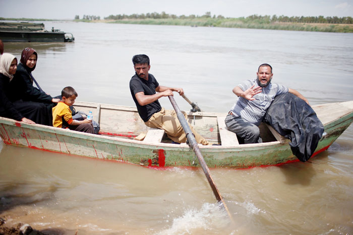 A displaced Iraqi holds the body of his wife, who was killed during the fighting in Mosul, on a boat carrying his family as they cross the Tigris River after the bridge has been temporarily closed, in western Mosul. — Reuters